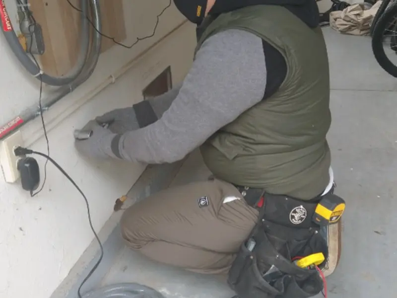 Electrician performing outlet wiring in a Hemet garage
